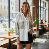 Sobre camisa de pana blanca con detalles en animal print en los bolsillos frontales y en las mangas. Presenta cuello inglés, cierre frontal con botones y corte holgado.