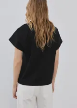 Remera negra de algodón, con diseño recto, cuello redondo y manga corta.