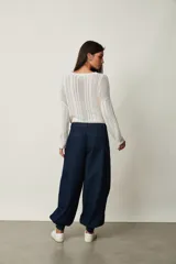 Pantalón tipo jean azul oscuro, de corte slouchy con pinzas en la cintura, bolsillos laterales y puños fruncidos con elástico en los tobillos.