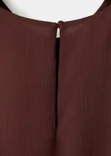 Vestido corto bordó con volantes en capas y tirantes anchos.