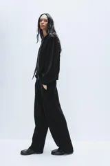 Pantalón de punto de tiro alto con bolsillos delanteros y bolsillos de plastrón en la parte trasera. Presenta una cintura doble ajustable con cordón en tejido a contraste.