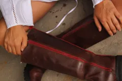 Bota de caña alta hasta la rodilla, confeccionada en cuero vacuno, con suela track de goma dentada y cierre lateral.