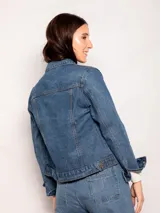 Campera de jean clásica con lavado vintage, corte corto, bolsillos frontales y cierre mediante botones metálicos.