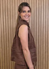 Musculosa marrón sin mangas, con cuello alto, escote en V y detalles de pespuntes blancos en contraste. Presenta pliegues y alforzas frontales.