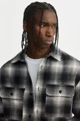 Sobrecamisa de franela con cuello inglés, cierre frontal de botones y dos bolsillos superiores con solapa. Presenta mangas largas con puños abotonados y bajo recto.