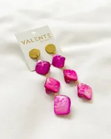Aros colgantes con base dorada y piedras nacaradas rosas en forma cuadrada, unidas por eslabones dorados.