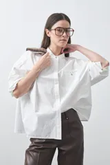 Camisa de manga larga en color celeste, con cuello mao y cierre frontal oculto. Presenta un diseño de silueta relajada con sisa caída y un bolsillo aplicado en el pecho.