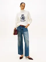 Sweater de Tommy Hilfiger confeccionado en pura lana, con cuello perkins y diseño de manga raglán. Presenta un escudo gráfico distintivo bordado en el pecho y acabados en punto canalé en cuello, puños y bajo.