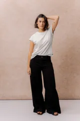Pantalón de jean negro de corte wide leg, tiro alto y con costura vertical frontal.