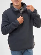 Buzo de polar color bordó con cuello alto y cierre frontal parcial. Cuenta con bolsillos laterales con cierre y detalles en cuero en los tiradores.