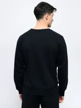 Buzo gris melange de felpa sin frisa, con cuello redondo y logo de Umbro bordado en azul marino en el pecho.