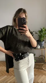 Buzo de tejido de punto color negro con lurex dorado, corte oversize y tajos laterales.