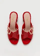 Sandalia de taco ancho color dorado, confeccionada en cuero vacuno, con diseño de tiras cruzadas y hebilla metálica decorativa.