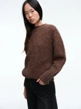 Sweater de tejido de punto con textura suave y acabado ligeramente afelpado, de corte holgado, cuello redondo y mangas largas.