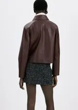 Chaqueta de cuero sintético marrón con cuello camisero, cierre frontal con botones oscuros y bolsillos frontales con solapa.