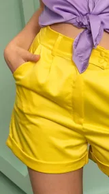 Short amarillo de satén con cintura alta y corte clásico.