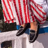 Mocasines de cuero color tostado, con punta cuadrada, costuras artesanales visibles y suela plana de goma.