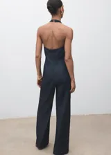 Mono largo de denim oscuro con cuello halter y espalda descubierta. Presenta un diseño de corte recto y holgado con bolsillos laterales y cierre de cremallera en la parte posterior.