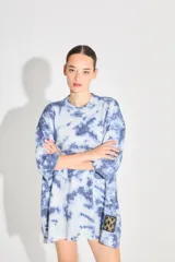 Sweater de punto tipo remerón oversize con diseño batik artesanal en tonos azul y blanco. Presenta silueta amplia, manga caída y etiqueta tejida con monograma en el frente.