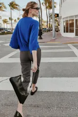 Jersey de punto liso color azul, con cuello redondo, botones delanteros y manga ancha por debajo del codo.