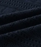 Remera tipo polo de manga corta con cuello en V, confeccionada en un tejido con textura patchwork. Presenta un diseño elegante y versátil, ideal para un look casual o formal.