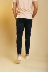 Pantalón de jean azul oscuro, corte ajustado, con cierre de botón y cremallera, y bolsillos laterales y traseros.