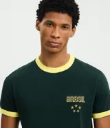 Remera de algodón color verde oscuro con cuello redondo y bordes de mangas en color amarillo. Presenta un bordado frontal con la palabra Brasil y estrellas en color amarillo.