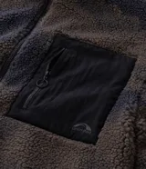 Campera de sherpa con estampado camuflado en tonos marrones y grises, de corte oversize y manga larga. Presenta cuello alto, cierre frontal completo y un bolsillo frontal contrastante en color negro con cierre.