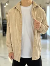 Sobrecamisa de pana color beige, de manga larga, con cuello clásico, cierre frontal de botones y un bolsillo aplicado en el pecho.
