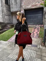 Bolso tote grande color bordó, con detalles en cuero negro en la base y las asas. Confeccionado en gabardina y forrado en tela Panamá.