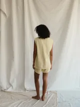 Chaleco color amarillo pálido con escote en V y sisas con terminación desflecada.
