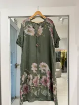 Vestido midi verde militar con estampado de flores rosadas, de manga corta con vuelta, cuello en V y detalles de botones circulares con cordones en la parte delantera.
