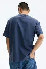 Remera de algodón de peso medio, color azul, con cuello redondo ribeteado, hombros caídos, bajo recto y corte holgado. Presenta un estampado frontal con la inscripción "SAN DIEGO" en blanco con efecto desgastado.