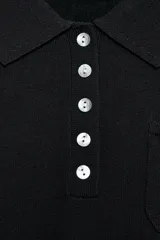Top negro de punto fino con cuello polo, manga corta, cierre frontal de botones y un bolsillo de parche en el pecho.
