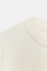 Jersey de punto con cuello redondo y manga larga, con terminaciones en tejido rib en cuello, puños y cintura.