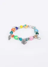 Pulsera elastizada con mostacillas de colores y dijes plateados con forma de mariposa, corazón y niña.