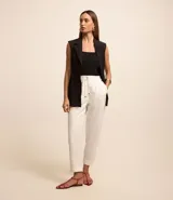 Pantalón de crepé blanco con lazo delantero en la cintura y elástico. Corte recto con botamanga arremangada.