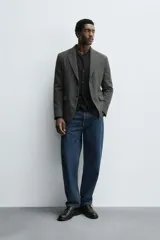 Blazer slim fit de estructura con diseño de pata de gallo, cuello con solapas de muesca, manga larga con botones en puños, bolsillos de solapa en cadera y cierre frontal con botones.