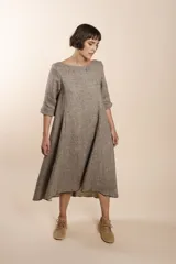 Vestido midi acampanado de lana fina sin teñir, con cuello bote, mangas tres cuartos con tajo y bolsillos laterales. Diseño forrado con vuelo y movimiento.