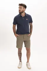 Remera tipo polo azul marino de manga corta con cuello clásico y cierre de dos botones. Presenta un pequeño bordado de un pájaro en el pecho.