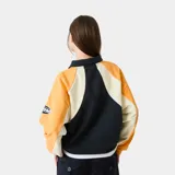 Polo de manga larga Eme Studios con diseño racing, confeccionado en algodón pesado. Presenta cuello tipo polo con cierre de botones, mangas raglán y paneles en colores amarillo, blanco y azul. Incluye logo bordado en el frente y detalles gráficos en las mangas.