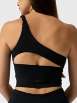 Top deportivo negro de un solo hombro con diseño frontal de cortes asimétricos y drapeado.