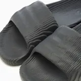 Sandalias Adidas Adilette 22 de diseño futurista en color negro, con patrón topográfico texturizado en relieve y suela de goma moldeada.