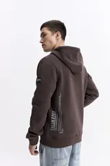 Campera con capucha y cierre frontal, color crema, con bolsillo canguro. Presenta un estampado de texto en el pecho y detalles en el puño.