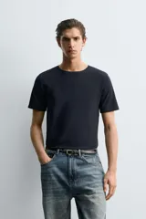 Camiseta de corte ajustado confeccionada en tejido de algodón con elasticidad, cuello redondo y manga corta.