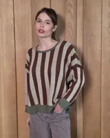 Buzo de punto con diseño de rayas verticales en tonos tostado y beige, con una estrella grande en la espalda y terminaciones en color verde oliva. Presenta un corte holgado y mangas anchas.