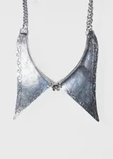 Collar plateado de aleación de metales con dije grande con forma de puntas y flor al centro.
