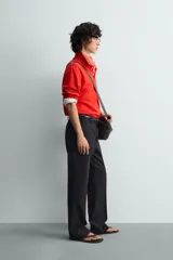 Polo de manga larga color rojo, confeccionado en tejido de algodón con estructura piqué, cuello solapa y cierre frontal de botonadura. Presenta aberturas laterales en el bajo.