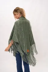 Ruana verde tejida en telar manual con lana merino. Presenta diseño con flecos y bolsillos de cuero natural.