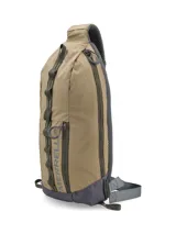 Mochila tipo morral Merrell modelo Crest de 8 litros, color tostado con detalles en gris oscuro. Presenta un diseño ergonómico con correa ajustable para uso ambidiestro, compartimento principal con acceso lateral, correas de compresión y panel trasero de espuma EVA.